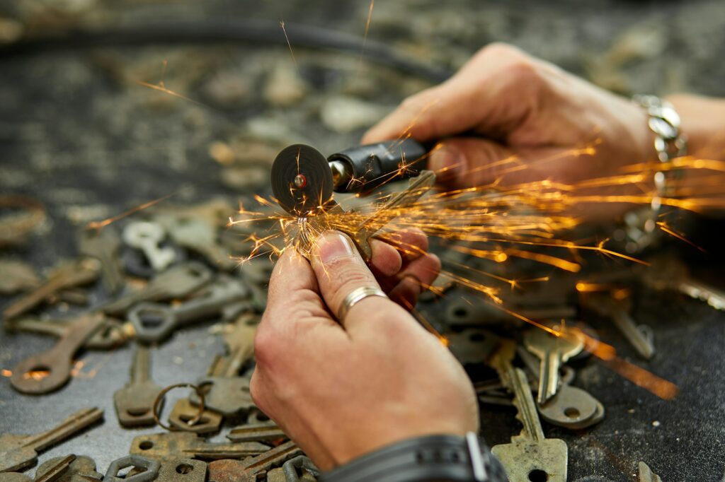 Locksmith in workshop makes new key, use grinding engraving machine